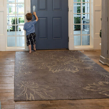 young child standing on a stylish area rug