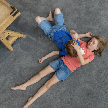 children laying on carpet flooring