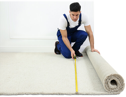 Carpet installer measuring floor with tape measure