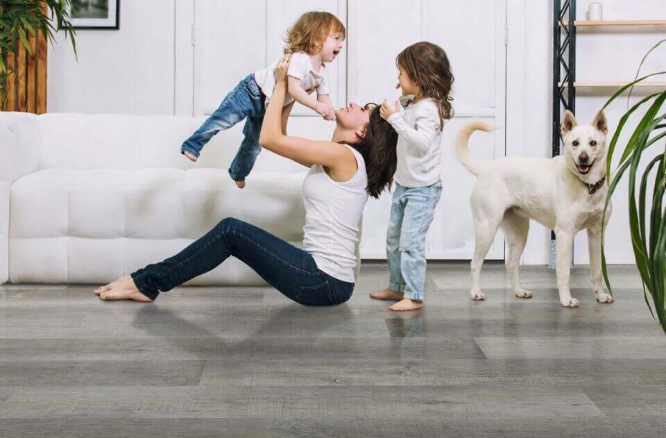 Mother and children playing on new wood flooring in living room