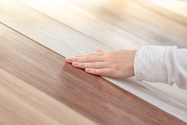 Shopper feeling wood flooring display at flooring store