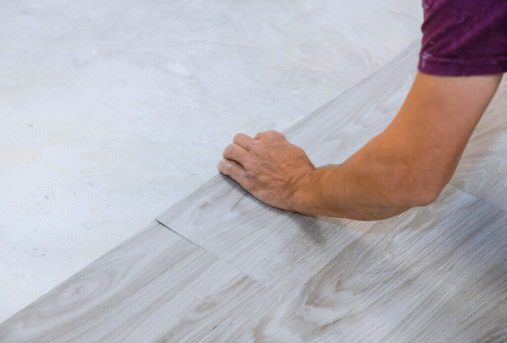 Installer laying luxury vinyl flooring